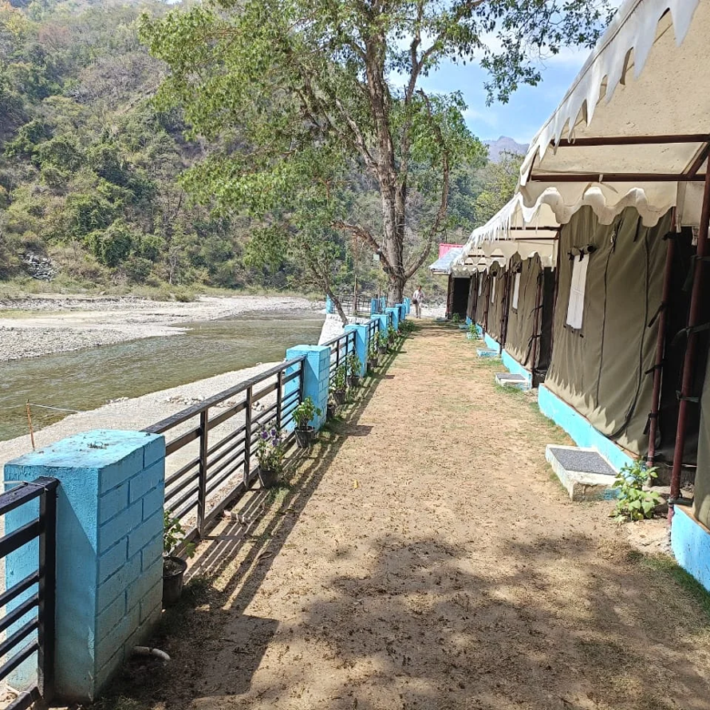 Camping tents in Mohan Chatti adventure zone near Rishikesh surrounded by forest hills